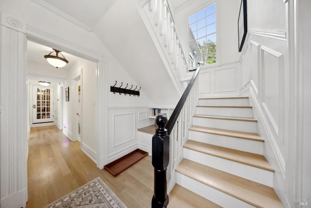 stairs featuring a decorative wall and wood finished floors