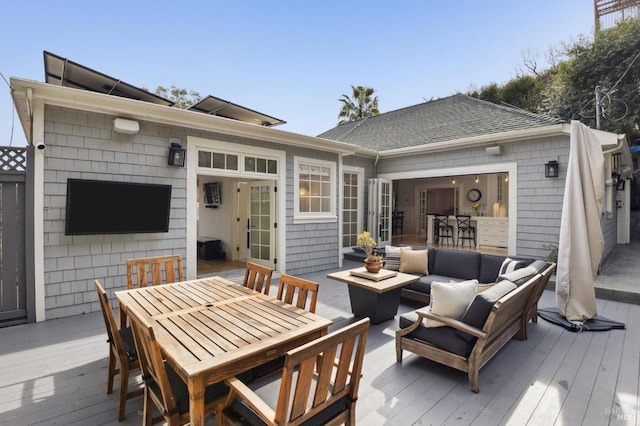 wooden deck with outdoor dining space and an outdoor hangout area