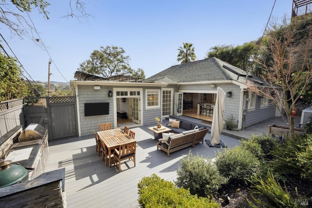 rear view of property with a wooden deck, a shingled roof, outdoor lounge area, and fence