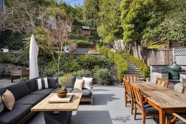 view of patio / terrace featuring outdoor dining space, fence, a wooden deck, grilling area, and outdoor lounge area