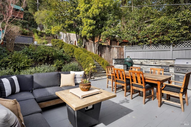 view of patio / terrace with outdoor dining space, an outdoor living space, an outdoor kitchen, and a fenced backyard