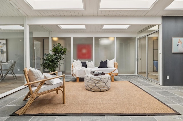 living room featuring a skylight and stone finish flooring