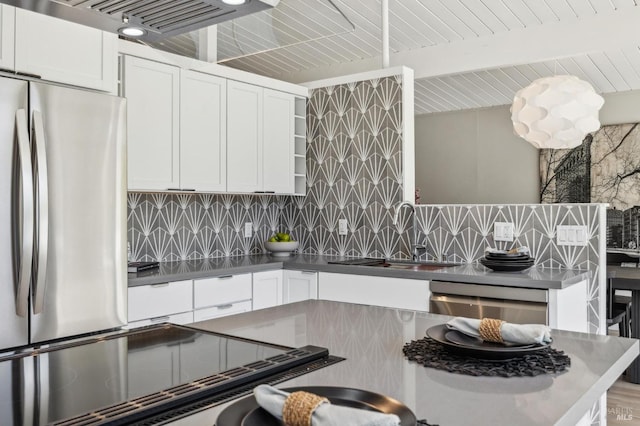 kitchen with a sink, open shelves, freestanding refrigerator, decorative backsplash, and dishwasher