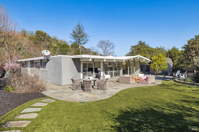 back of house with stucco siding, a lawn, a patio, and fence