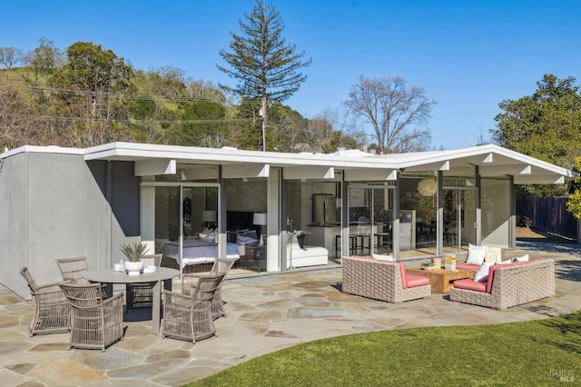 back of house with outdoor dining area and a patio area