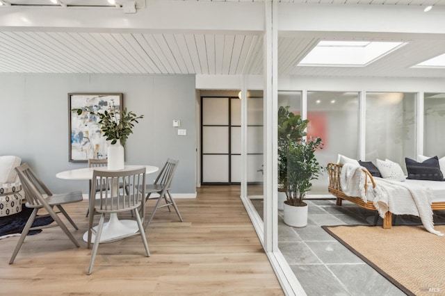 dining space with light wood finished floors and a skylight