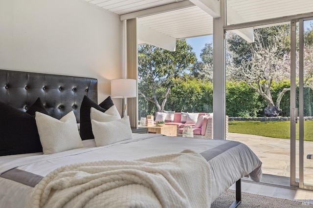 bedroom featuring access to exterior, floor to ceiling windows, multiple windows, and wood finished floors
