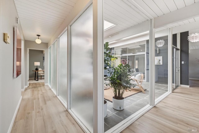hall with baseboards and wood finished floors
