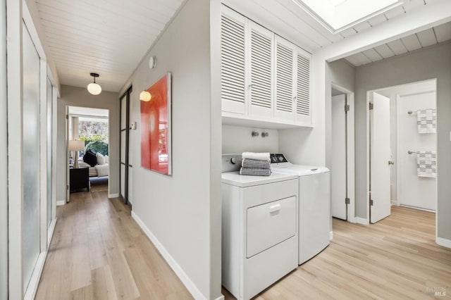 clothes washing area featuring cabinet space, wooden ceiling, baseboards, and light wood-style floors