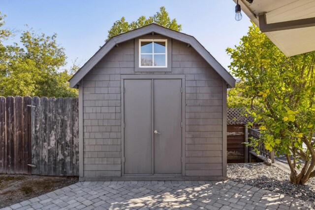 view of shed featuring fence