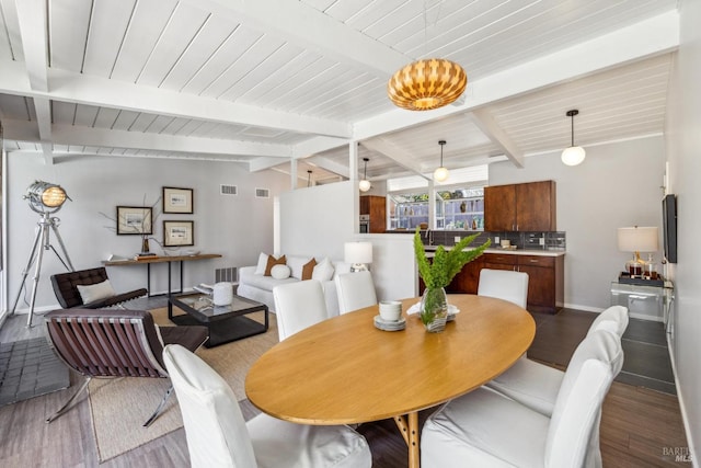 dining space with lofted ceiling with beams, visible vents, and wood finished floors