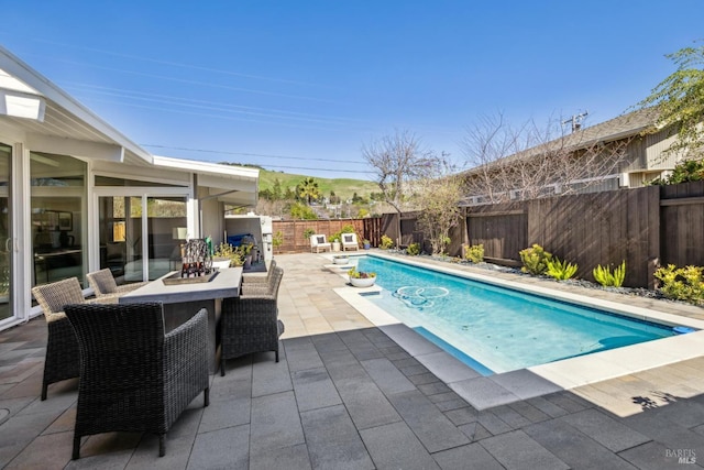 view of swimming pool with a patio area, a fenced in pool, outdoor dining area, and a fenced backyard