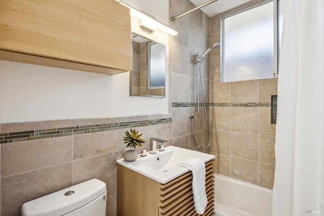 full bathroom with shower / bathing tub combination, toilet, tile walls, and vanity