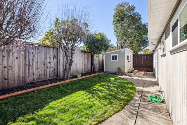 view of yard with an outbuilding, a storage unit, and a fenced backyard