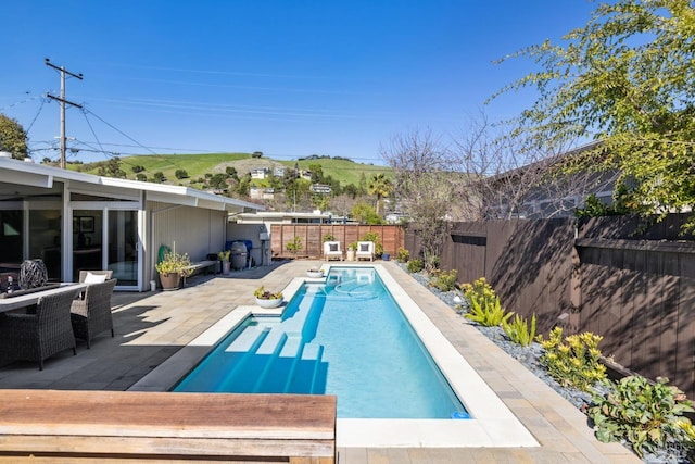 view of pool featuring a patio area, a fenced backyard, and a fenced in pool