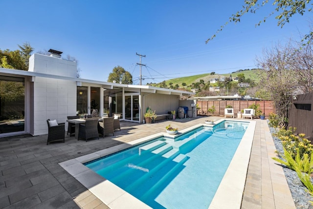 view of swimming pool featuring a fenced in pool, a fenced backyard, and a patio area