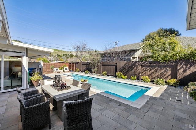 view of swimming pool featuring a fenced in pool, a fenced backyard, and a patio area