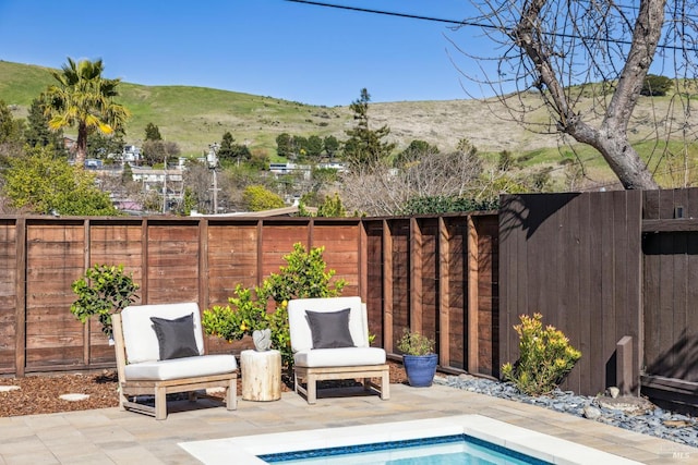 view of patio / terrace featuring a fenced backyard and a mountain view