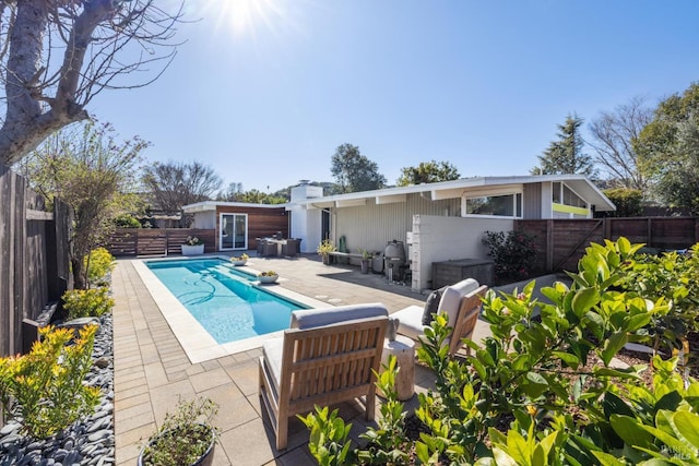 back of house featuring a patio area, a fenced in pool, and a fenced backyard