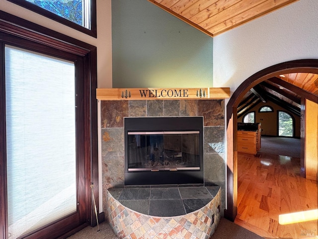 details featuring wood finished floors, arched walkways, and a tile fireplace