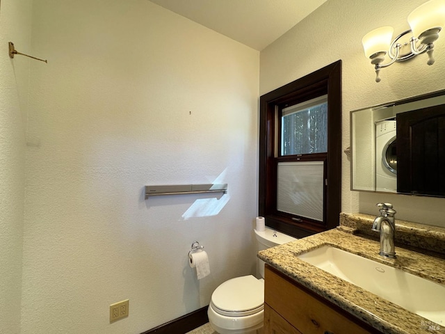 half bathroom with toilet, vanity, and stacked washer / dryer