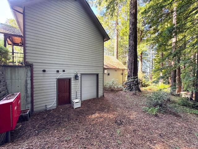 view of side of home featuring driveway and an attached garage