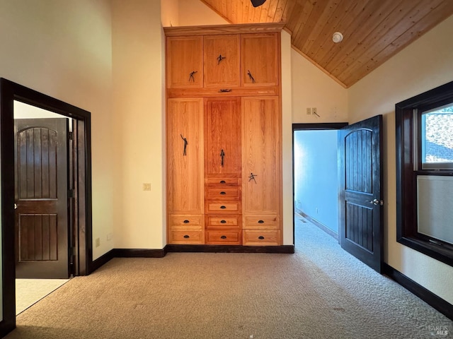 unfurnished bedroom featuring baseboards, carpet, wooden ceiling, and high vaulted ceiling