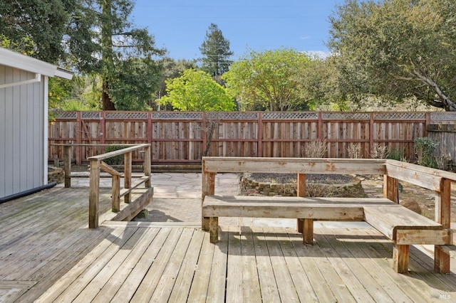 wooden terrace with a fenced backyard