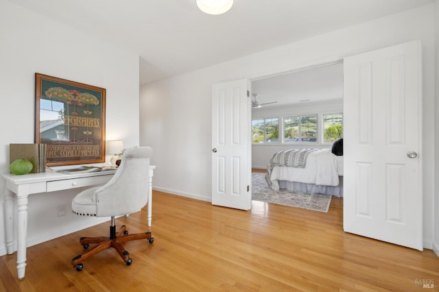 office area featuring light wood-type flooring and baseboards