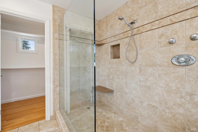 full bath with baseboards and tiled shower