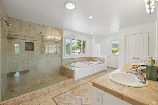 bathroom featuring a garden tub, a walk in shower, a sink, tile patterned flooring, and double vanity