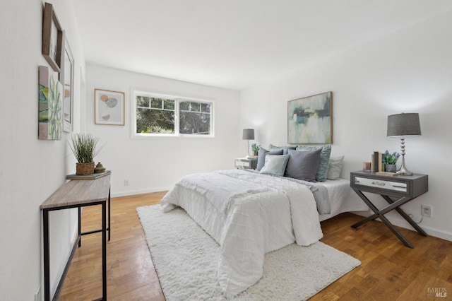 bedroom with baseboards and wood finished floors