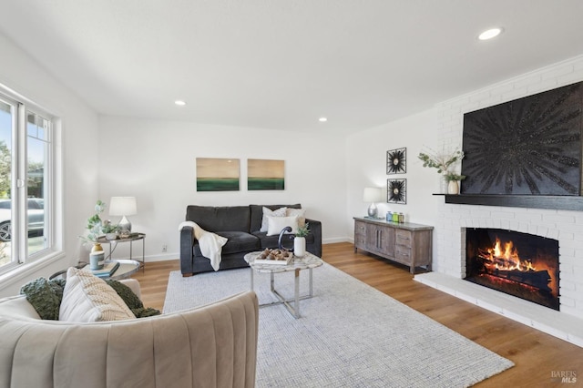 living room featuring a brick fireplace, recessed lighting, wood finished floors, and baseboards