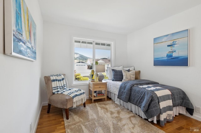 bedroom with baseboards and wood finished floors