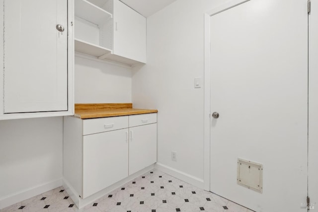 laundry area featuring baseboards and light floors