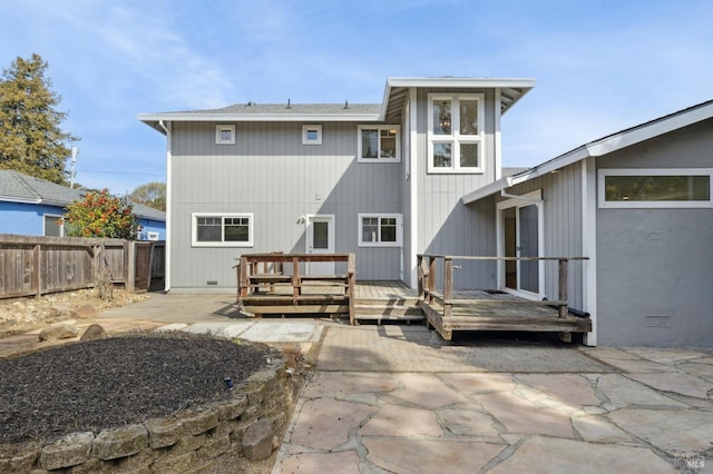 rear view of property featuring crawl space, a patio area, a wooden deck, and fence