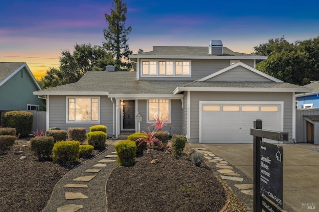 traditional-style house with an attached garage, a chimney, driveway, and fence