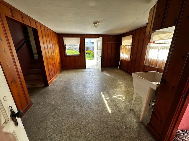 interior space featuring baseboards and wood walls