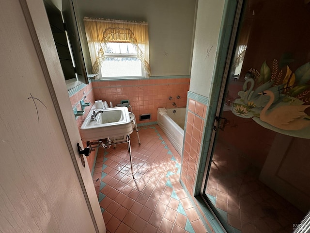 bathroom featuring tile patterned flooring, a shower stall, a bath, tile walls, and a sink