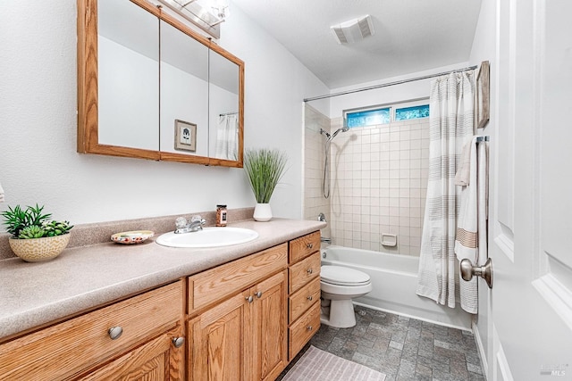 bathroom featuring visible vents, stone finish flooring, toilet, shower / tub combo with curtain, and vanity