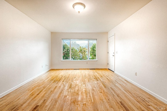 empty room featuring light wood-style flooring and baseboards