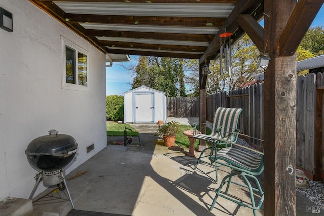 view of patio / terrace featuring an outbuilding, a shed, grilling area, and a fenced backyard