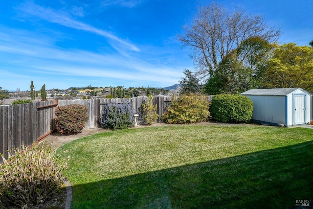 view of yard featuring an outbuilding, a storage unit, and a fenced backyard