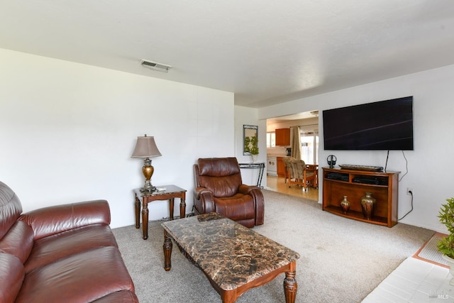 living area with visible vents and carpet