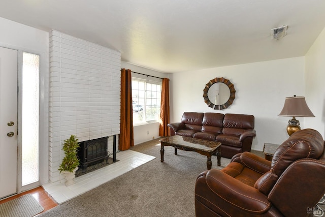 living area with visible vents, a large fireplace, and carpet