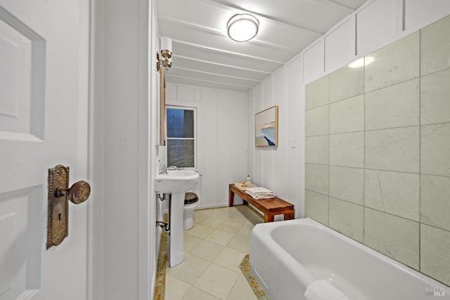 bathroom with tile patterned floors and a tub to relax in