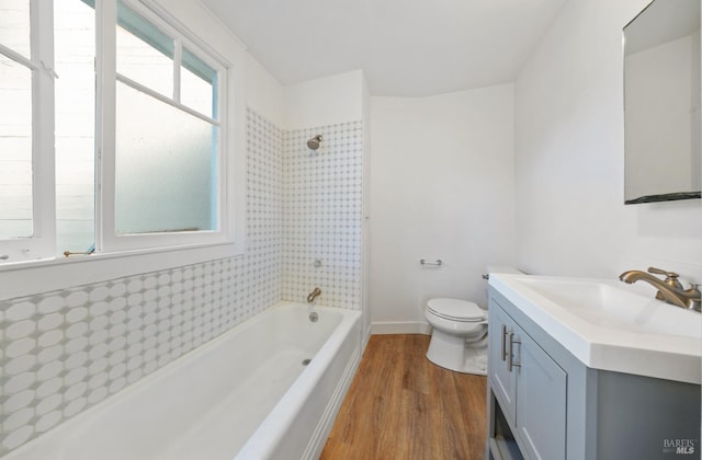 full bath with tub / shower combination, baseboards, toilet, wood finished floors, and vanity