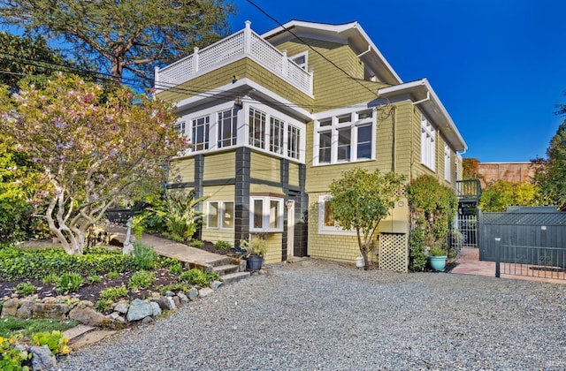 view of front of house with a balcony and fence