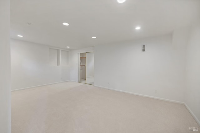 spare room with recessed lighting, baseboards, and light carpet