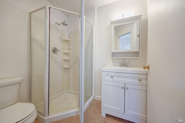 full bath with toilet, a stall shower, vanity, and tile patterned flooring